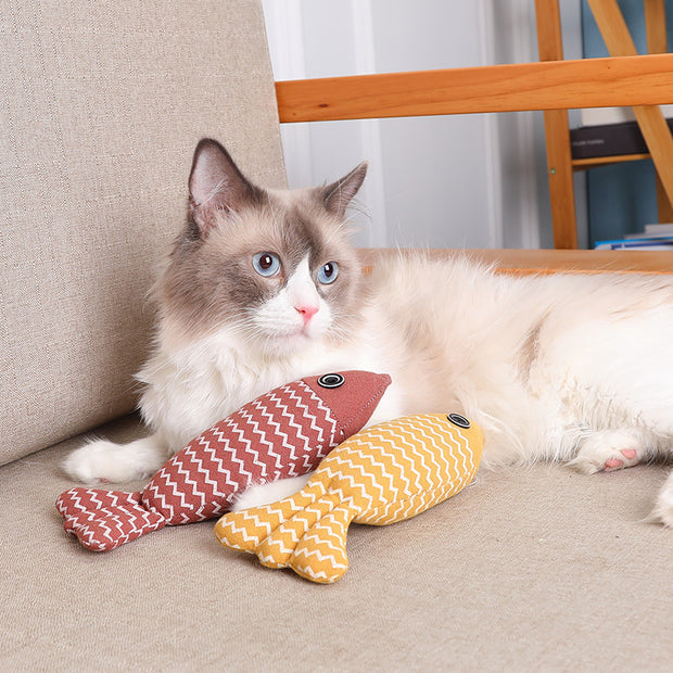 Cat lounging with two Cat Toy Funny Cat Linen Fish Pillows in yellow and red, ideal for biting and interactive play.