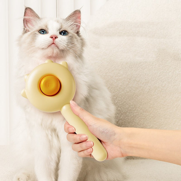 Cat being petted with a yellow handheld massage tool against a neutral background